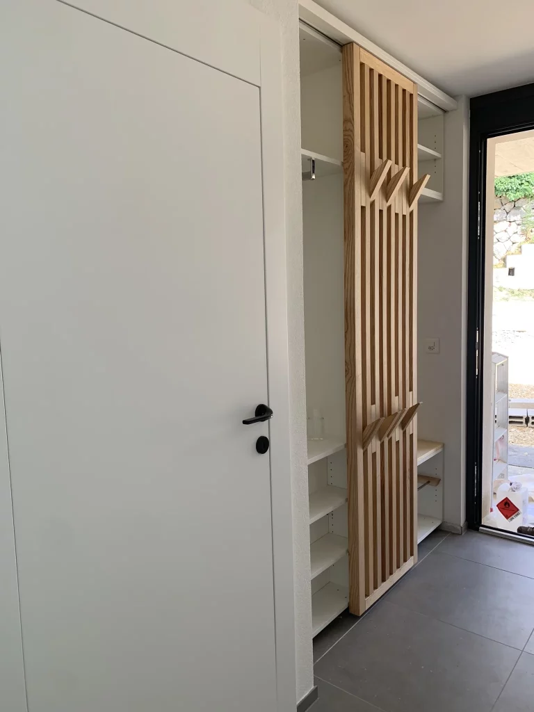 Meuble d'entrée avec claustra bois coulissant réalisé sur mesure par Solutions Bois