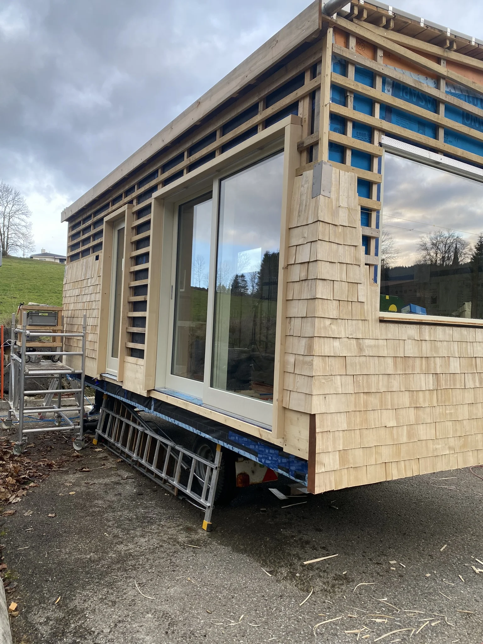 Tiny house en bardage bois avec fenêtres coulissantes en cours de pose par Solutions Bois