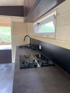 Cuisine intérieure de la tiny house avec plan de travail noir réalisée par Solutions Bois