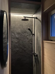 Douche italienne en pierre noire de la tiny house réalisée par Solutions Bois